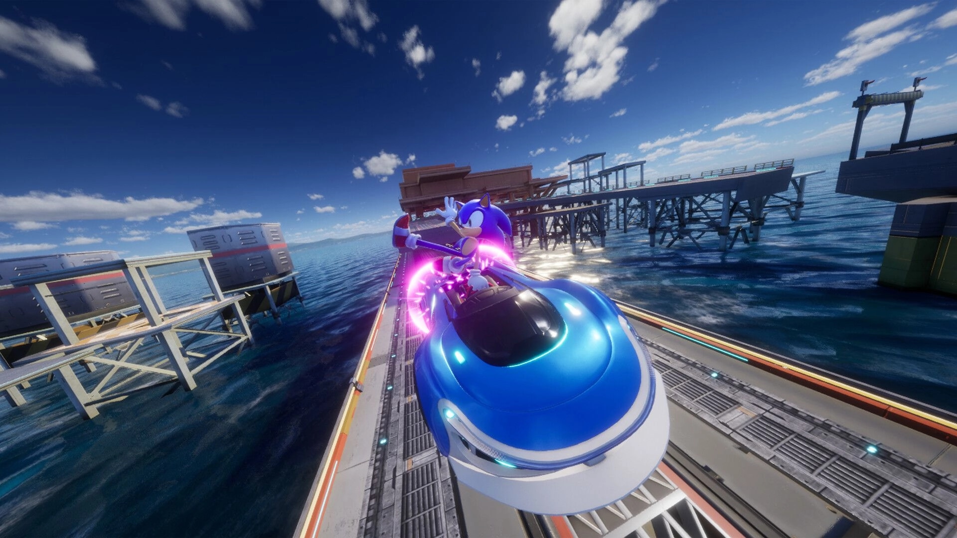 Sonic Racing: Sonic speeds in a blue car on a coastal track with platforms over the water.