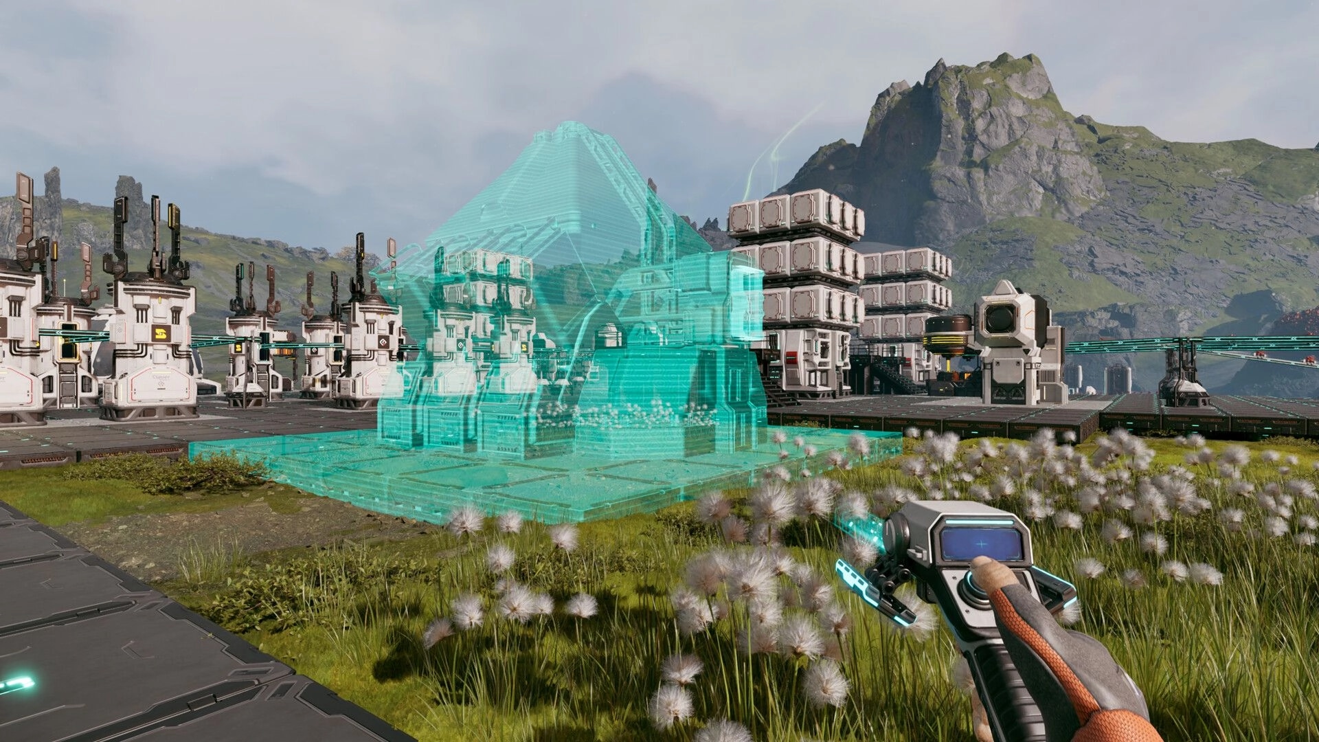 StarRupture: Player constructing a futuristic base with hologram overlay in a lush mountainous landscape
