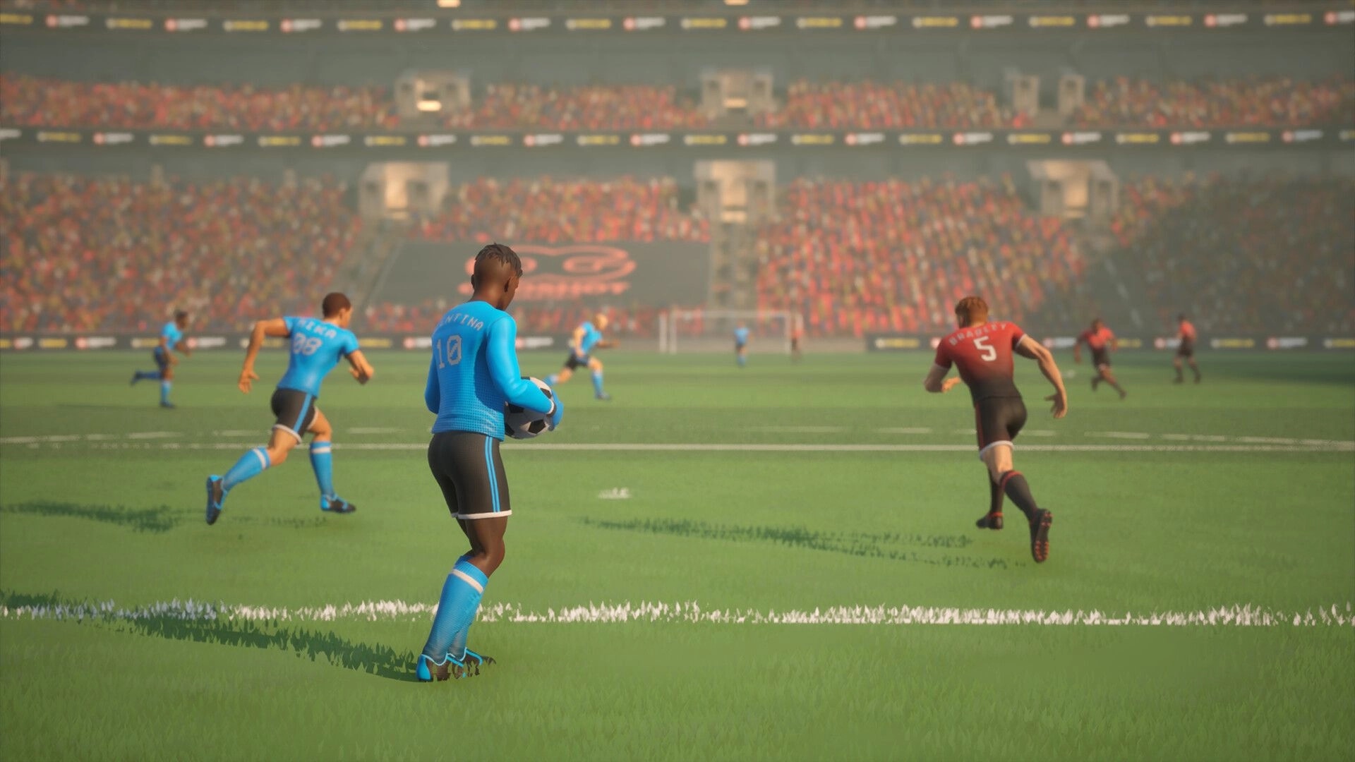 Strikers Club: Player in blue jersey prepares pass in stadium with cheering crowd in background
