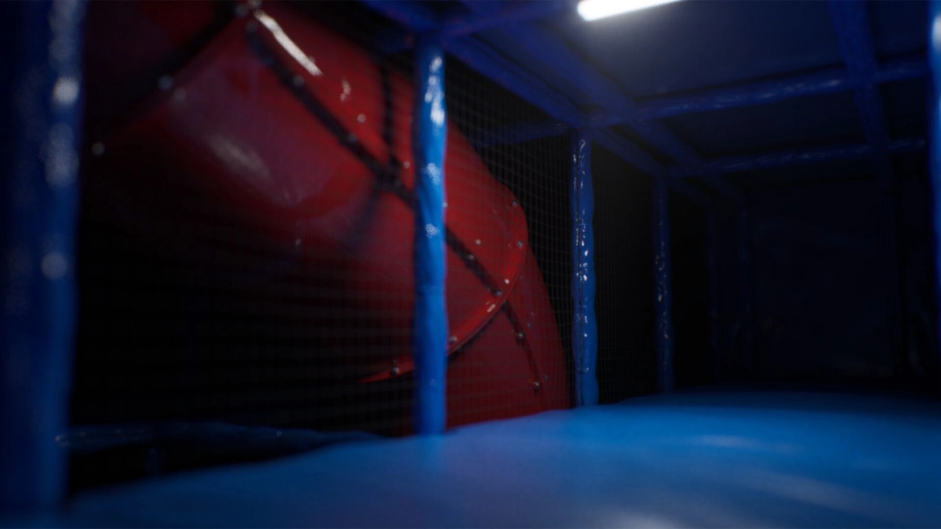 Subliminal: Dark play area with blue padded walls and red spiral slide in eerie lighting