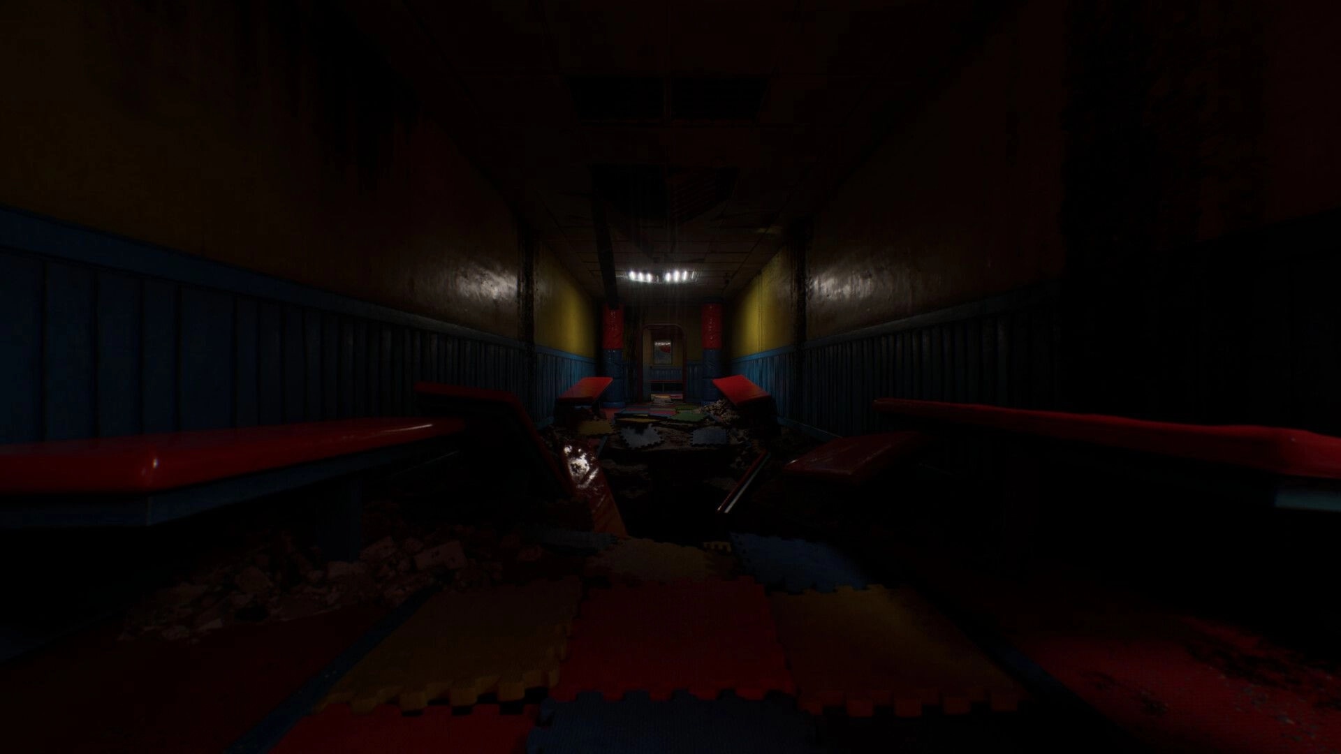 Subliminal: Dimly lit hallway with scattered debris and colorful mats, evoking eerie, unsettling vibes.