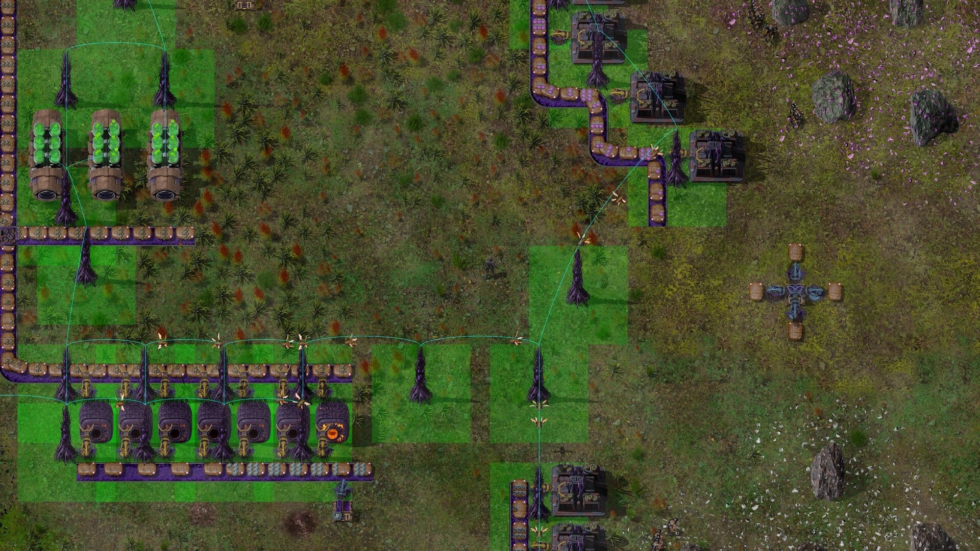 Swarmdustry: Conveyor-fed organic machines and turrets linked by power lines on grassy factory grid.