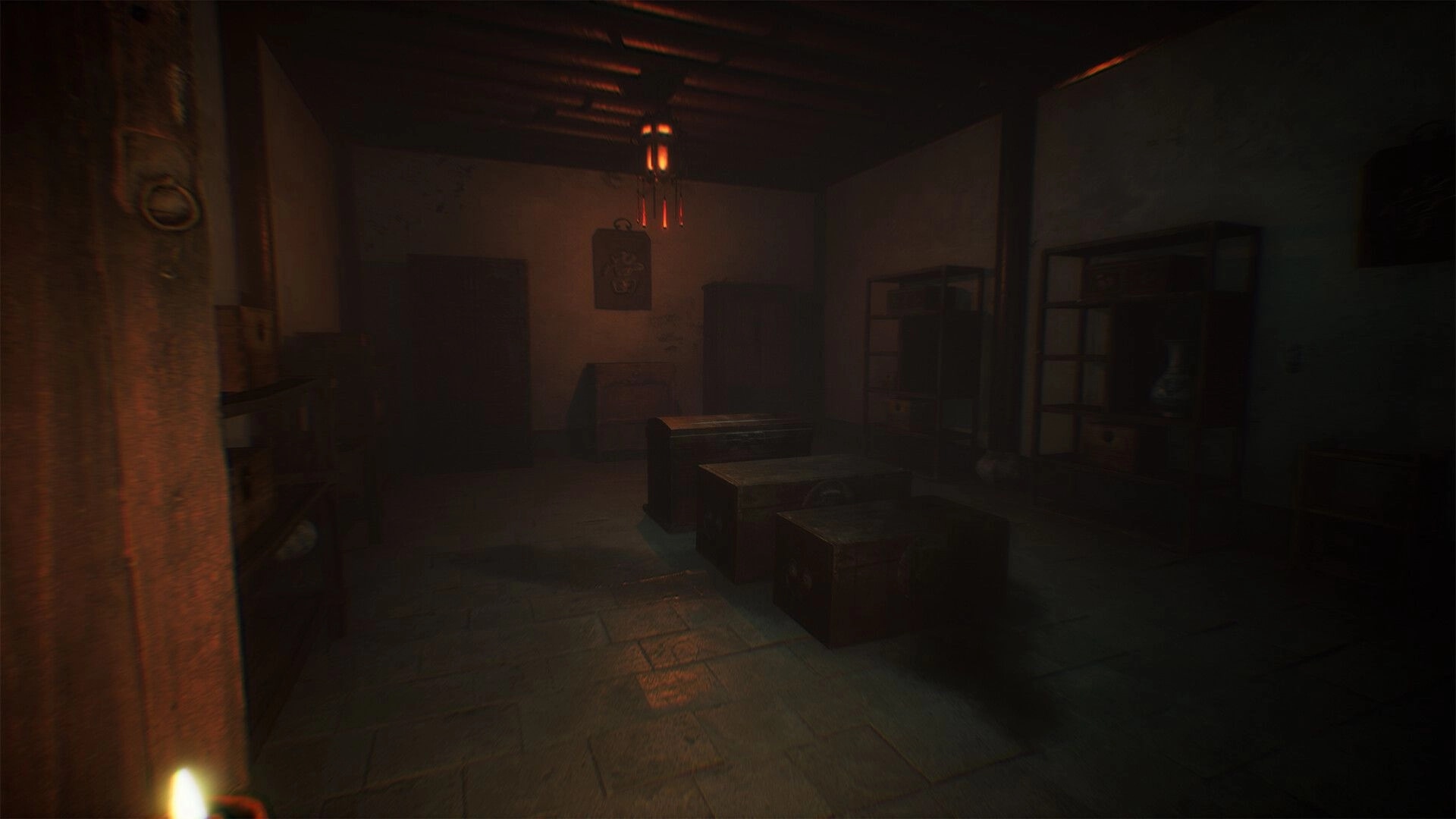 The Grotto Diary: First-person view into a dim room with stacked chests and shelves under a red lantern.