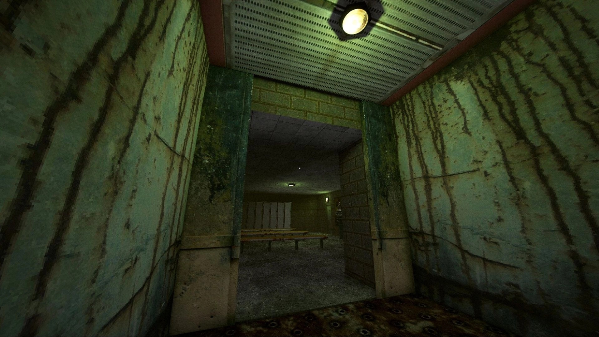 The Hollowing: First-person view down a grimy corridor with benches and lockers under dim lights.