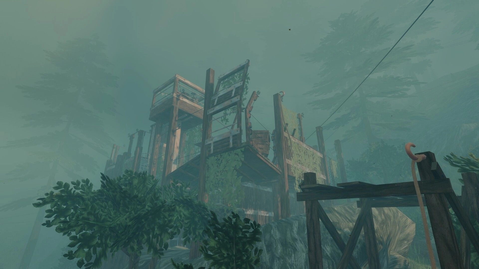 The UNDA Legacy: Misty wooden scaffold platforms and cables overlooking a foggy forested cliffside.