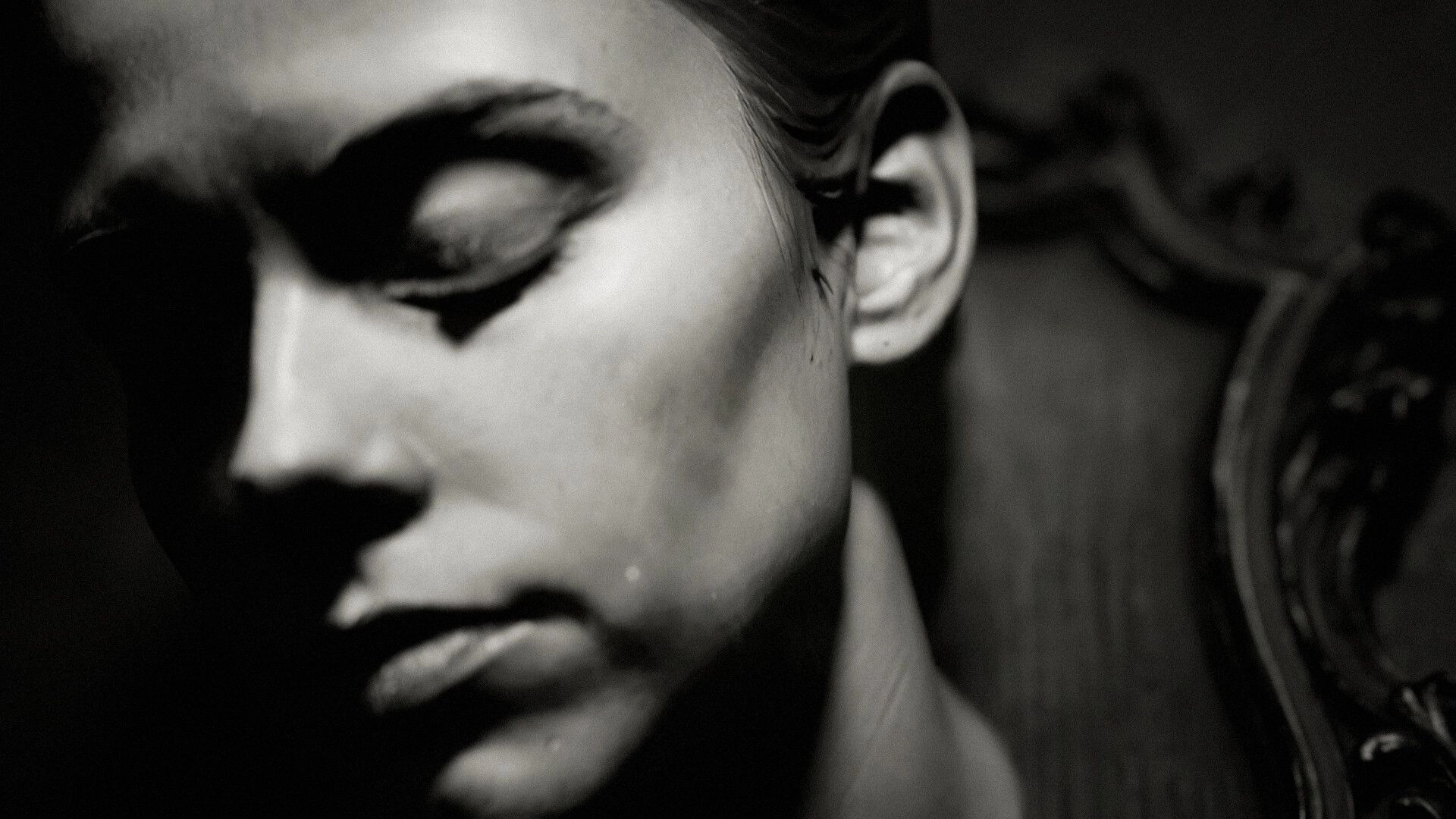 The Unworthy: Extreme close-up of a man's face with closed eyes in grainy black-and-white darkness.