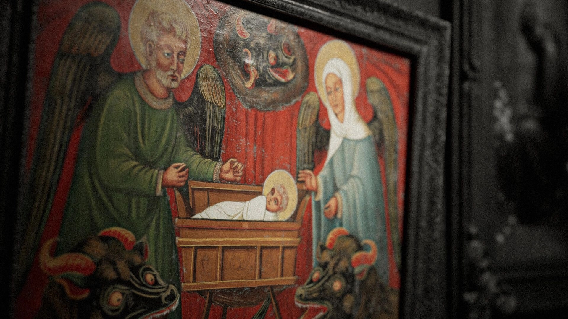 The Unworthy: Close-up of a worn religious painting with angels and a haloed baby in a crib.