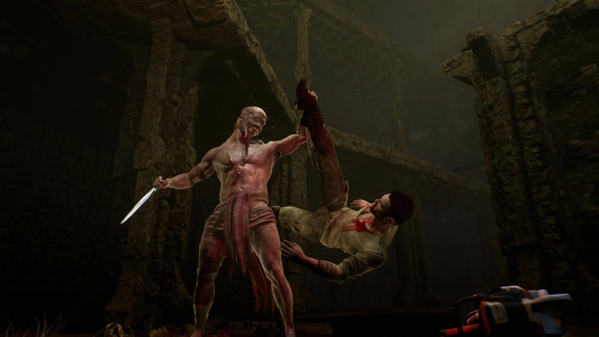 TORMENTOR: Masked figure stands over wounded captive in dimly lit stone dungeon with blood-stained floor.