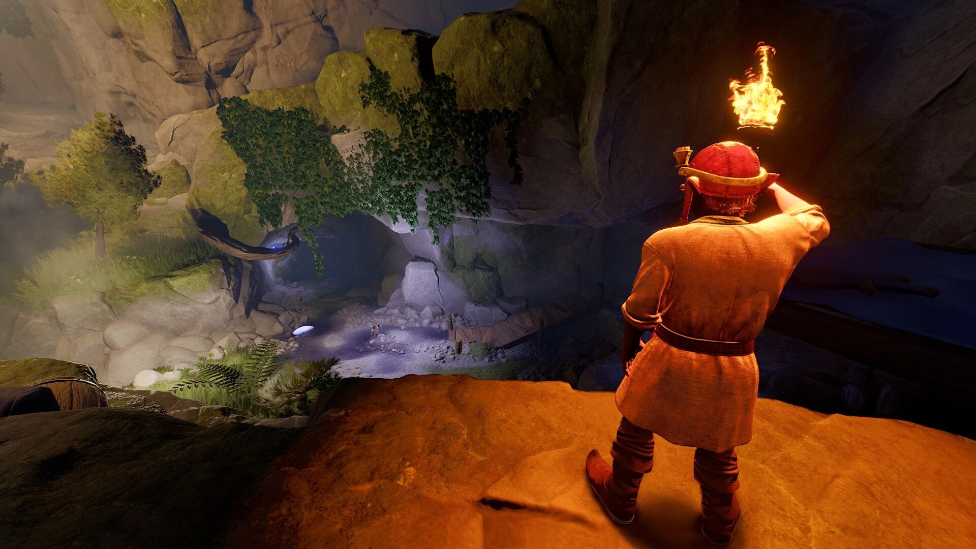 Toto’s Journey: Torchlit explorer overlooks a vine-covered canyon path and cave entrance from a ledge.