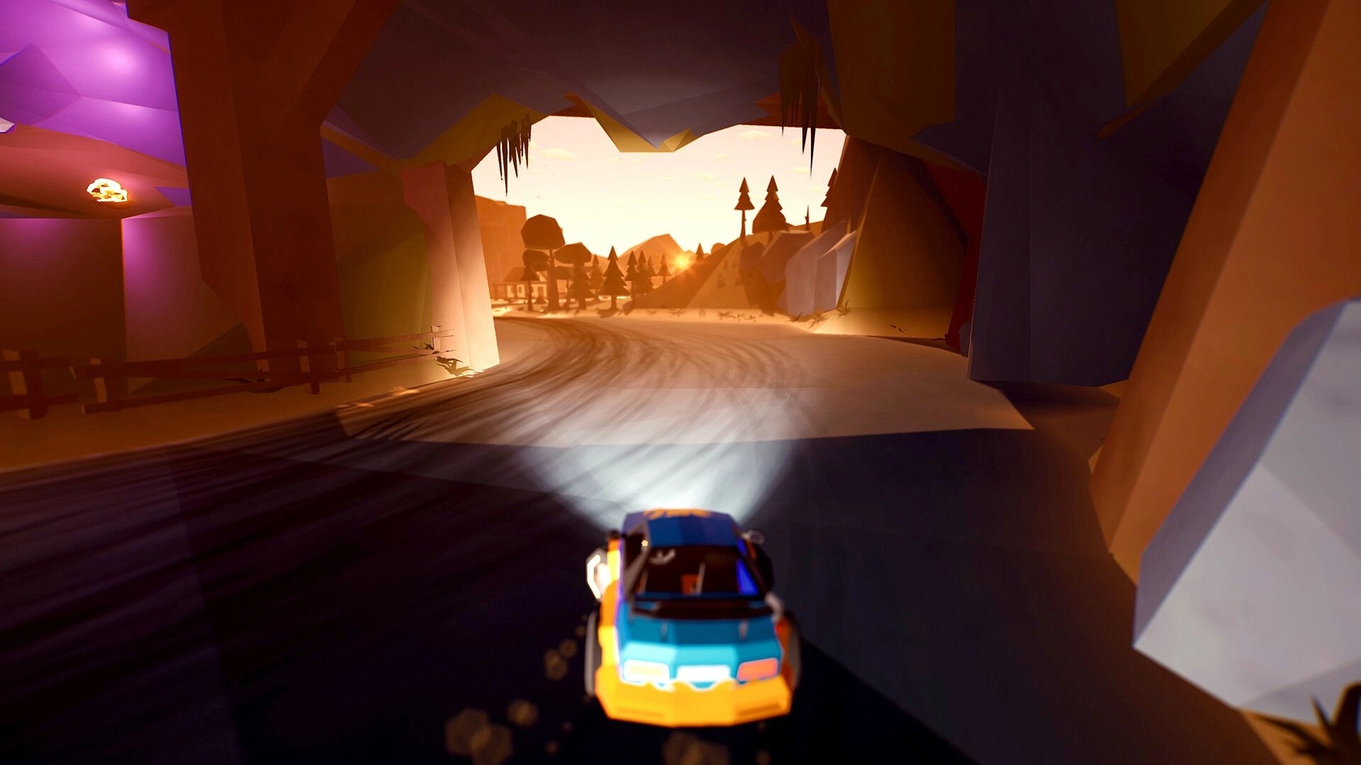 Traks: Third-person view of a blue-orange car racing out of a cave onto a sunset dirt track.