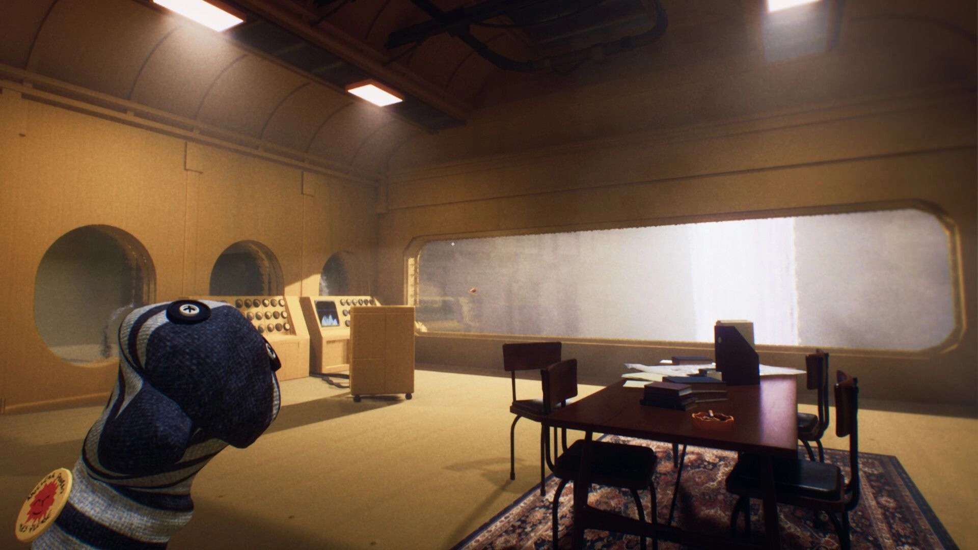 Transit: Sock puppet character in foreground beside table and control consoles in sunlit train cabin.