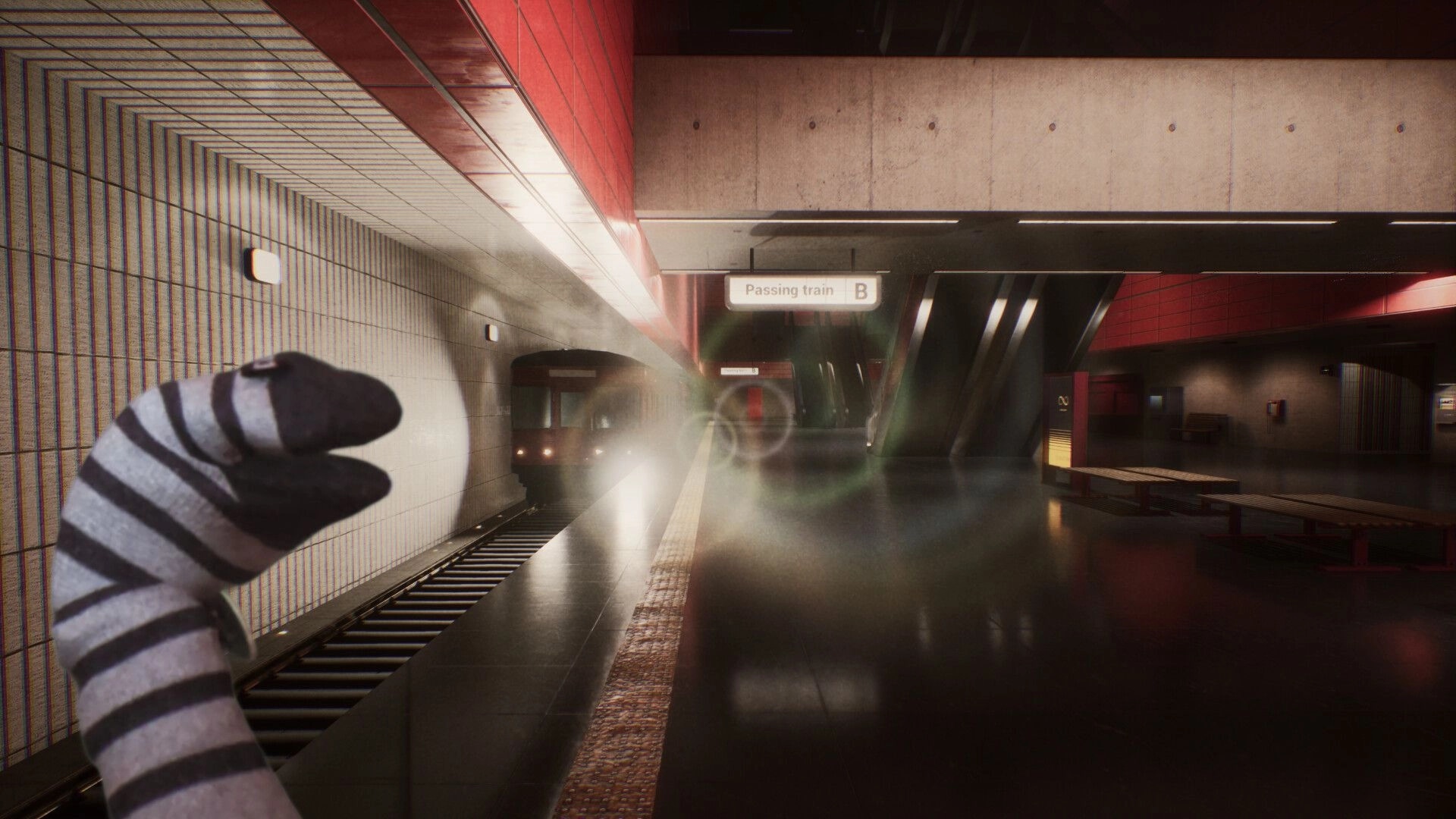 Transit: Sock puppet in foreground watching a subway train arrive at a red-tiled station platform.