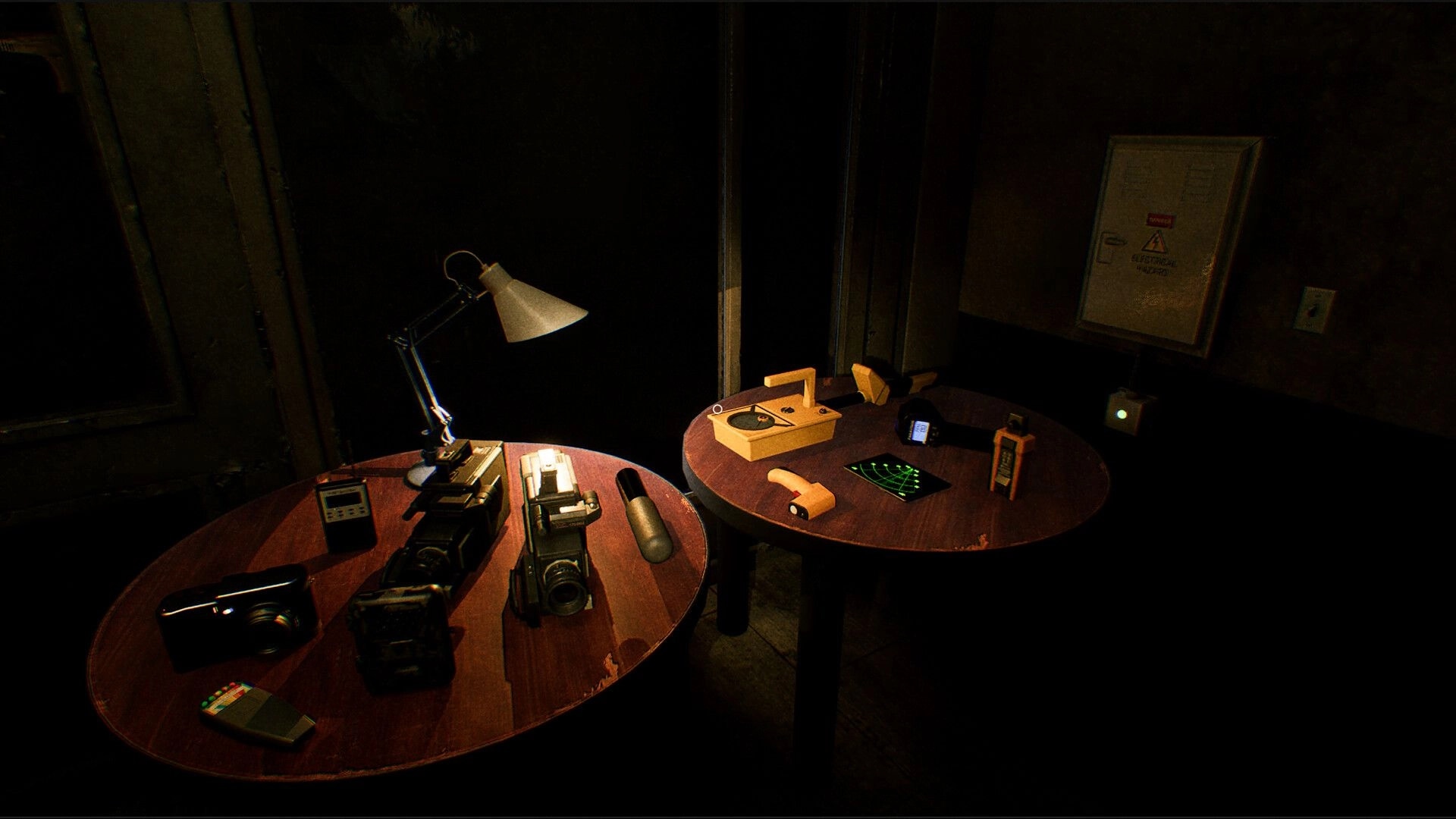 UFOPHILIA: Equipment table with cameras, detectors, and a radar screen in a dimly lit room.