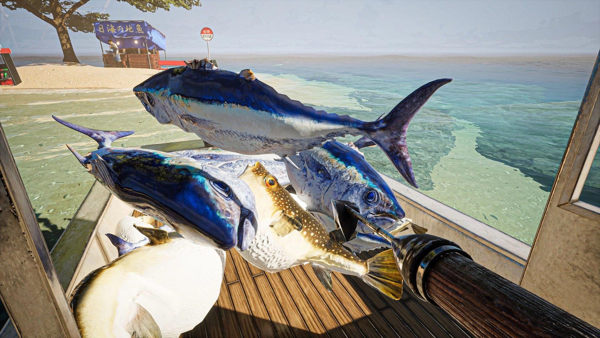 UMIGARI | ウミガリ: Harpoon with diverse fish on boat deck near a beachside market stall.