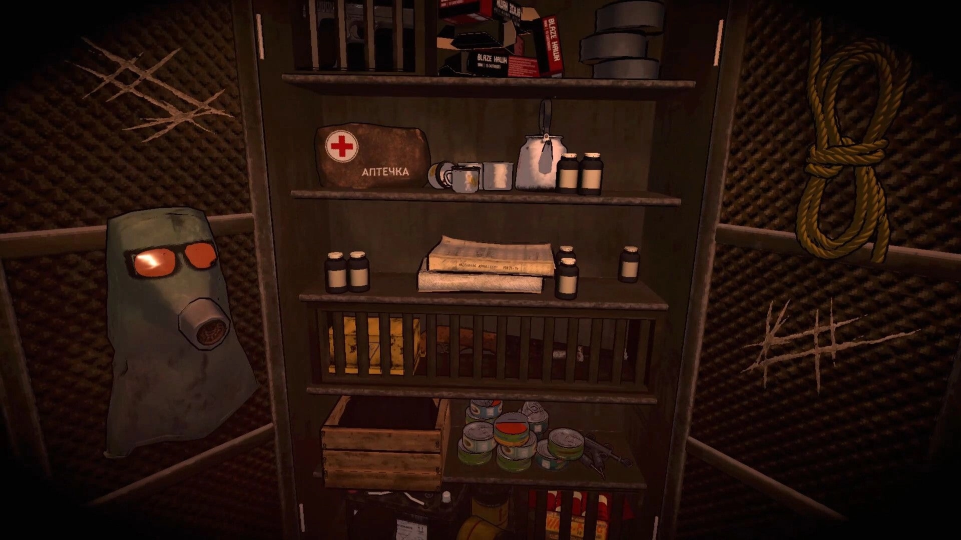 Uncanny Valley: Supply cabinet with medkit, pills, gas mask and rope inside a padded bunker room.