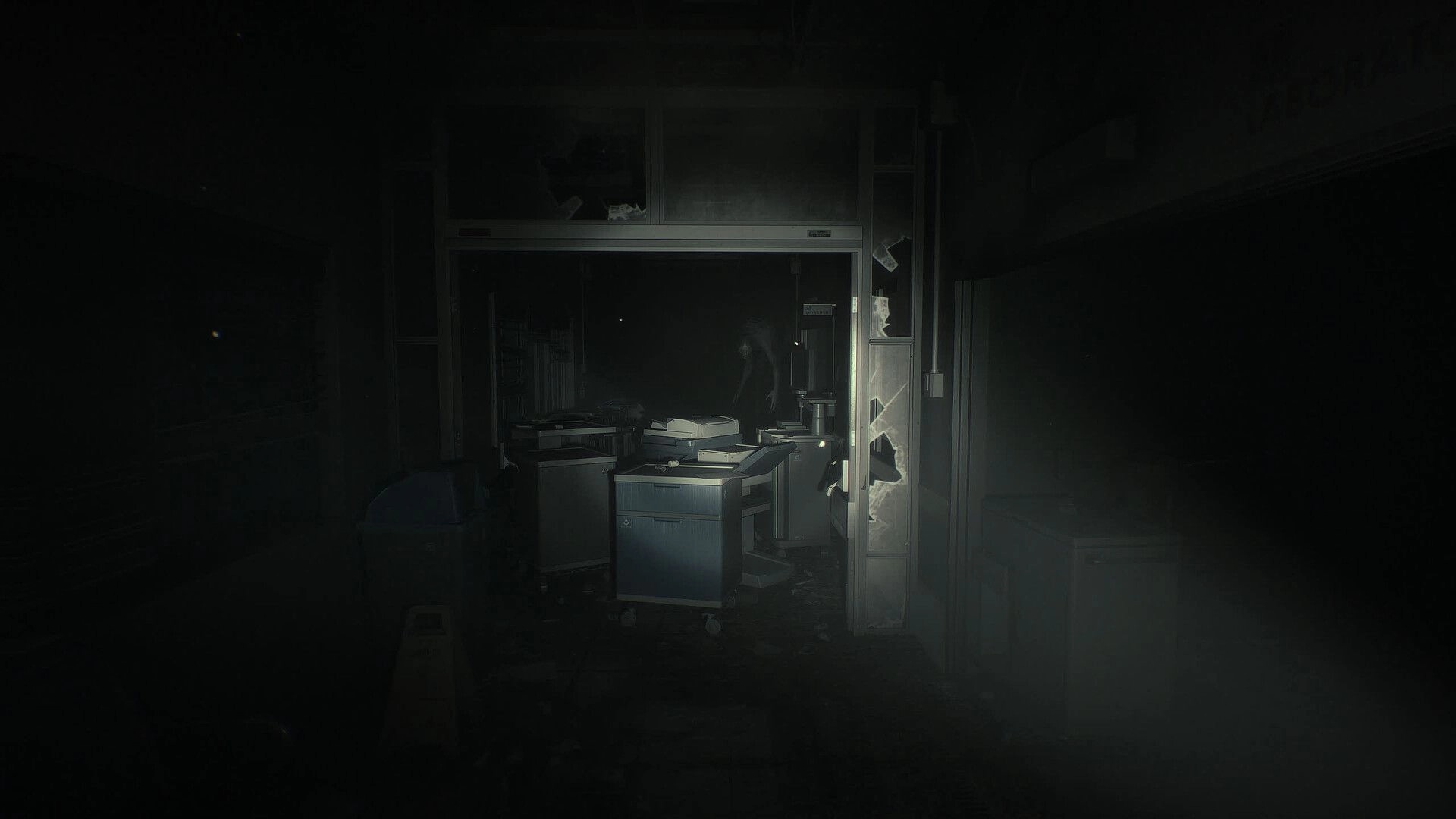 Unlisted: Flashlight view into a dark office with toppled desks and a shattered glass doorway.