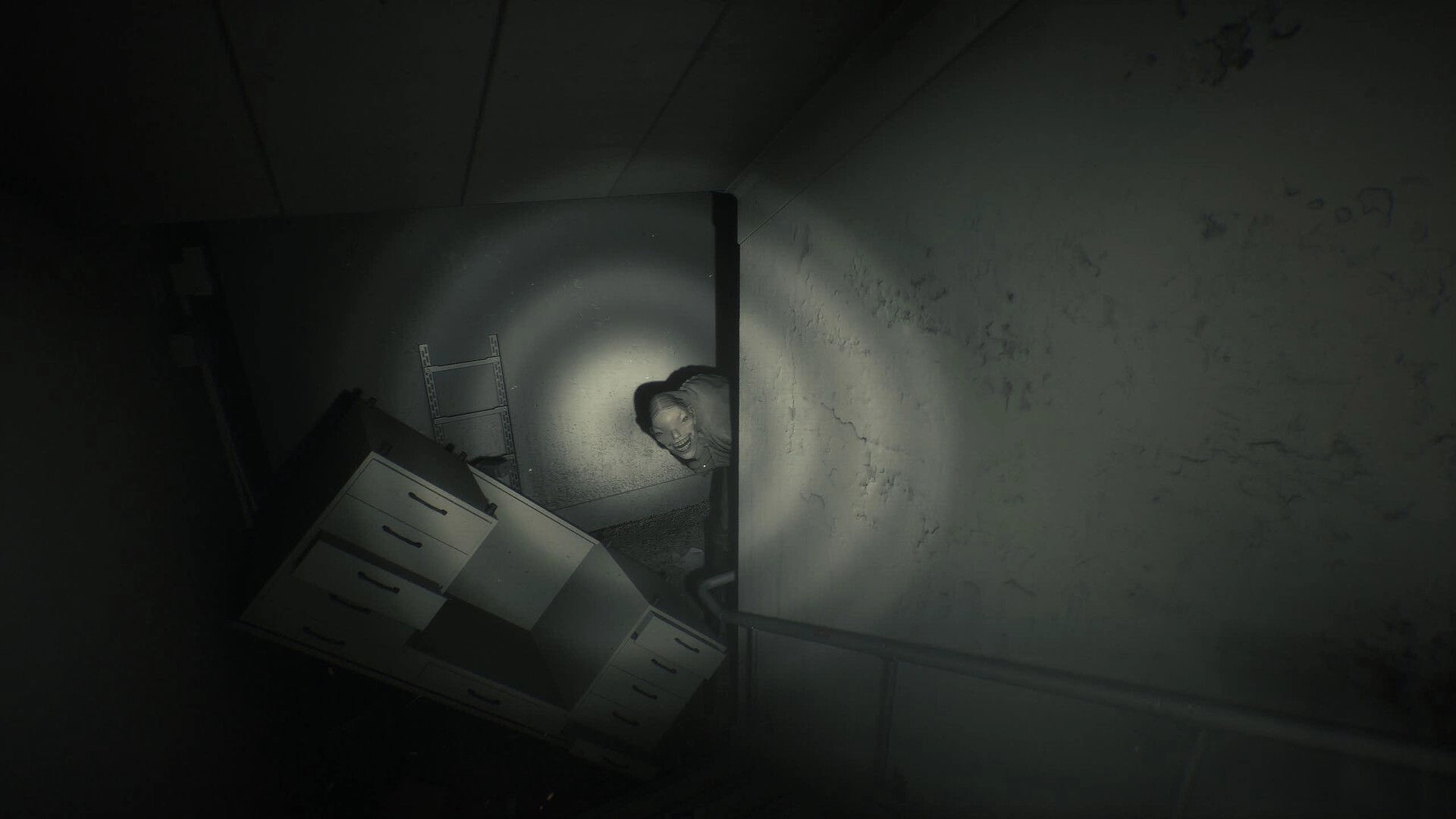 Unlisted: Flashlight reveals a pale figure peeking around a corner in a cluttered basement room.