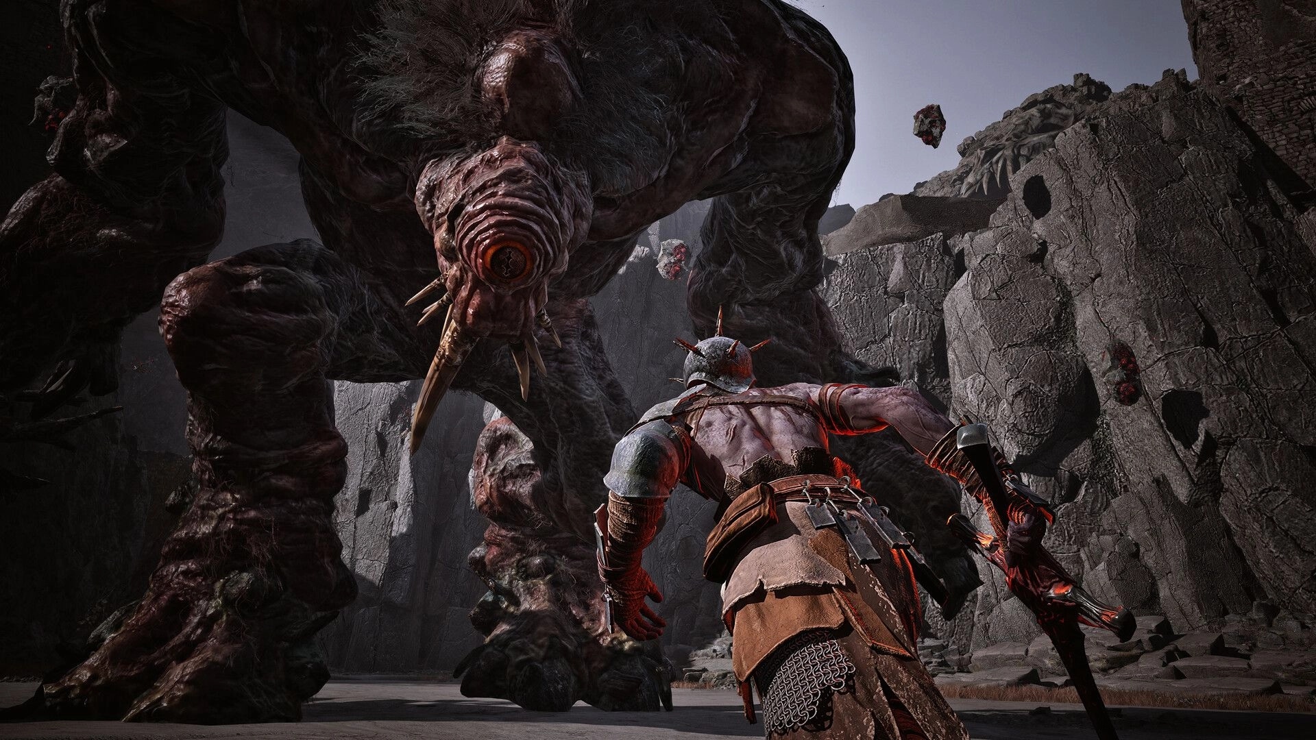 VANRAN: Armored warrior faces towering cyclops-like beast in rocky canyon arena, weapon drawn.
