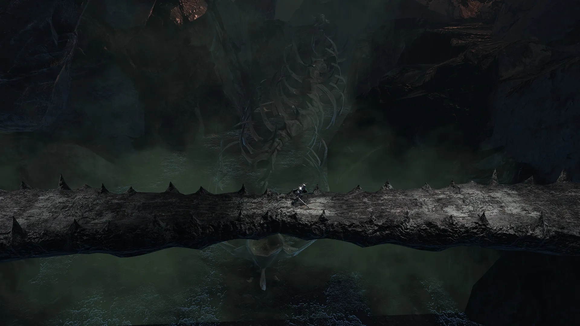VELASTER: Player crosses a spiked bridge over a vast, foggy chasm with a giant skeleton in Malum