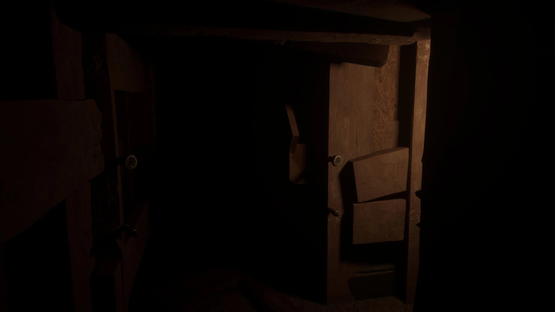Vellar: First-person view of a dusty wooden cabinet with open drawers in a dark, cramped room.