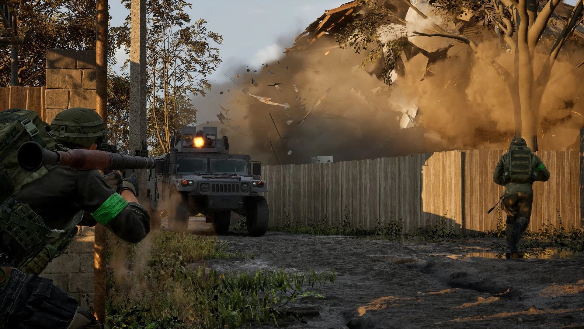 WARDOGS: Soldier aims rocket launcher as armored truck fires, house explodes in muddy village yard.