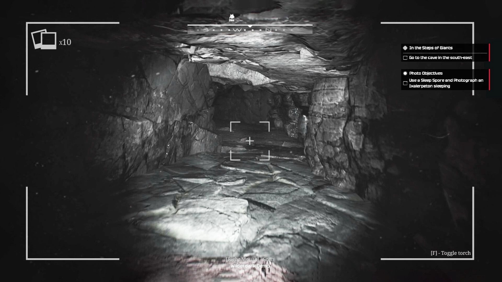 Wilderdark: Camera view aiming down a rocky tunnel with quest objectives panel in a dark cave passage.