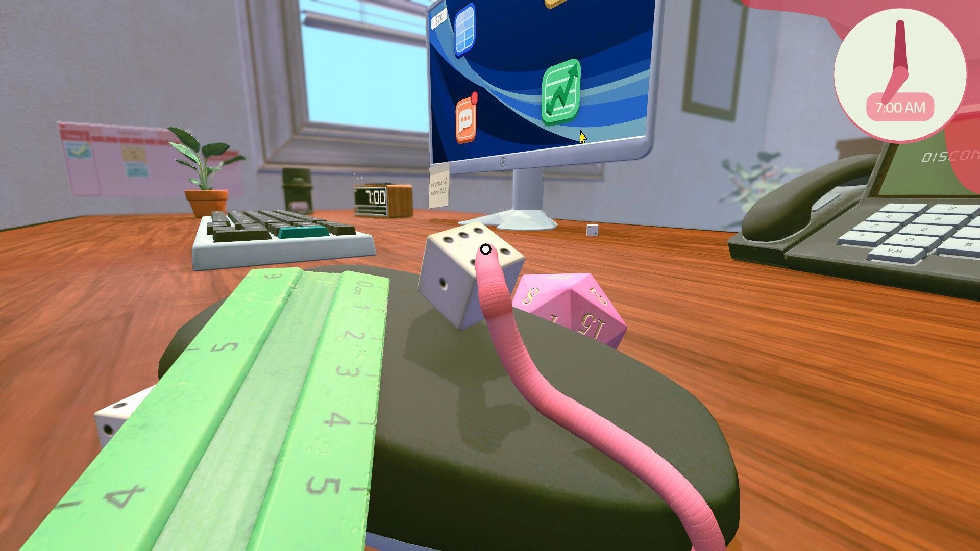 Worming from Home: Pink worm interacts with dice on a cluttered office desk near a computer screen.