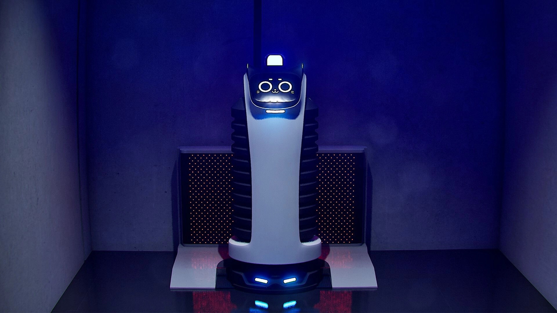 Zangyou: Close-up of a glowing security robot with a cartoon face in a blue-lit office corner.