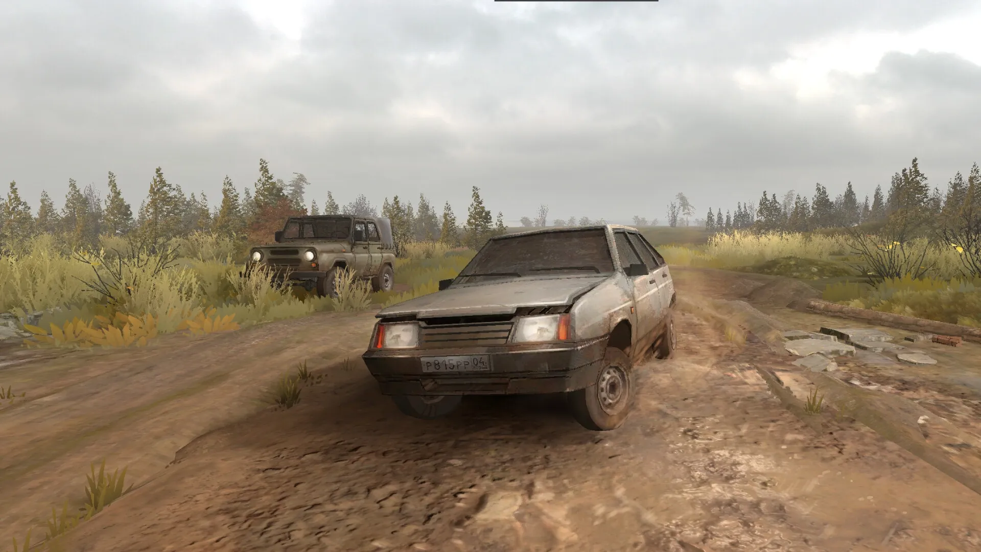 Zarya: Two cars driving on a muddy rural road surrounded by fields and trees under a cloudy sky.