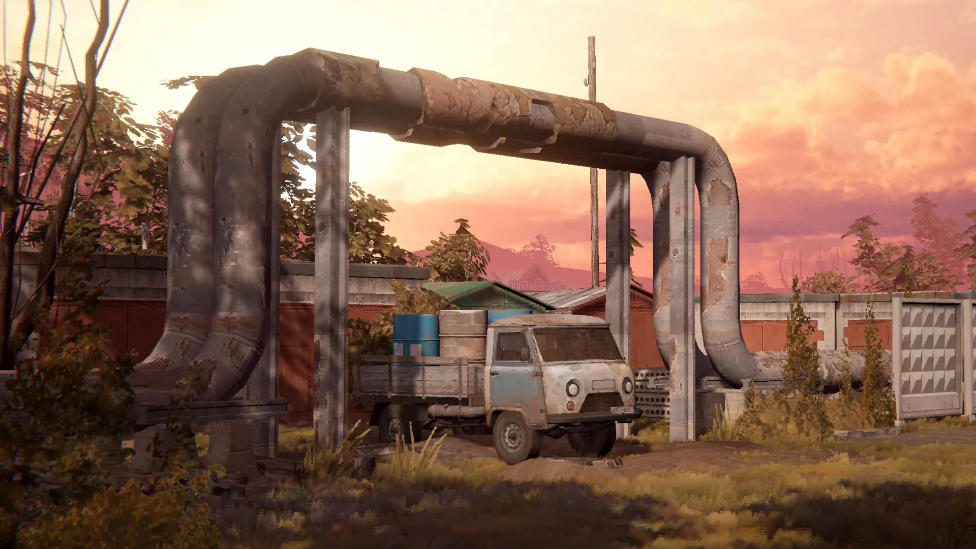 Zarya: Rusty truck parked under large pipes in a rural area with a sunset sky in the background