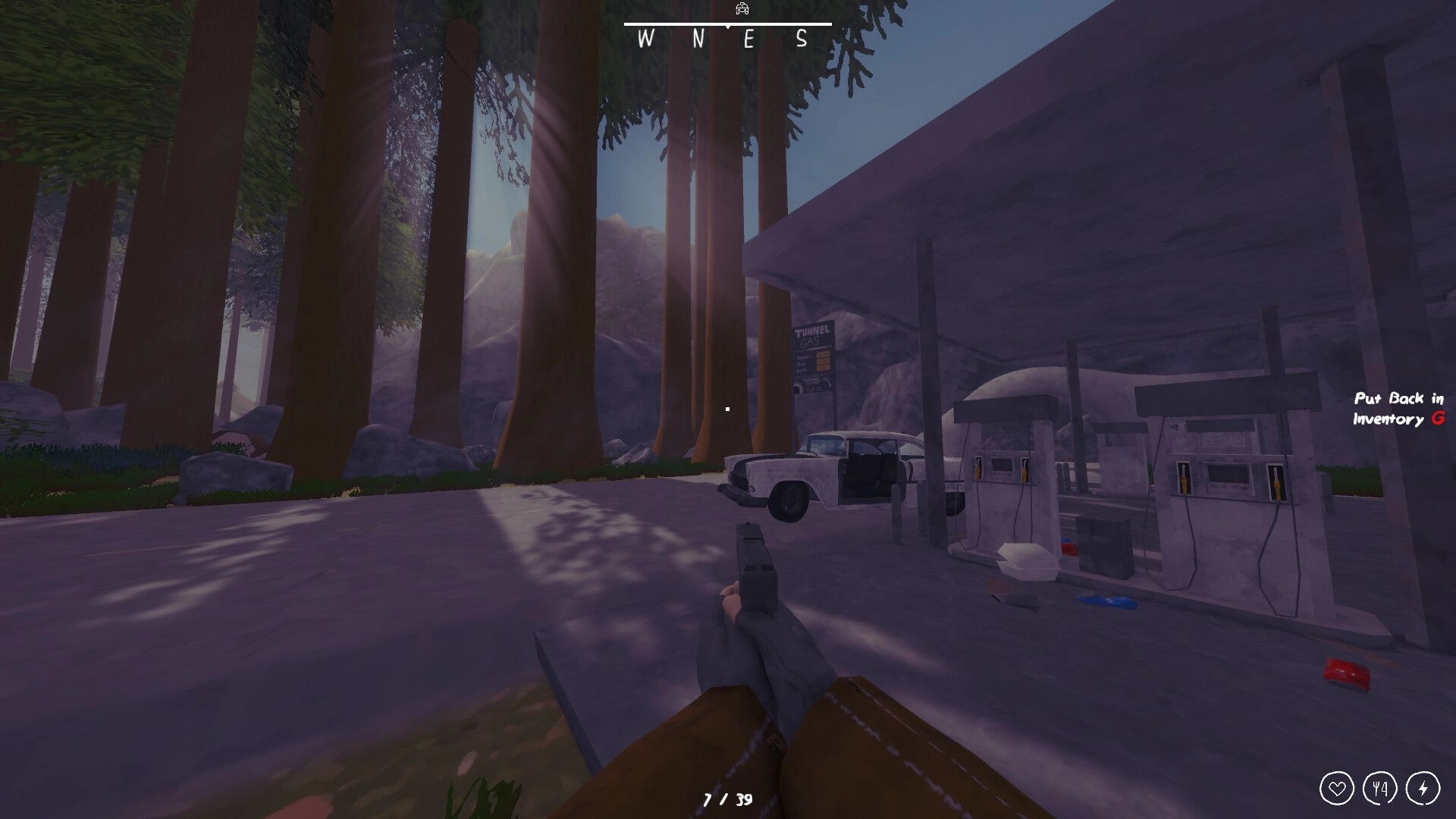 Zero To South: First-person view aiming pistol at abandoned gas station beside tall forest trees, HUD compass.